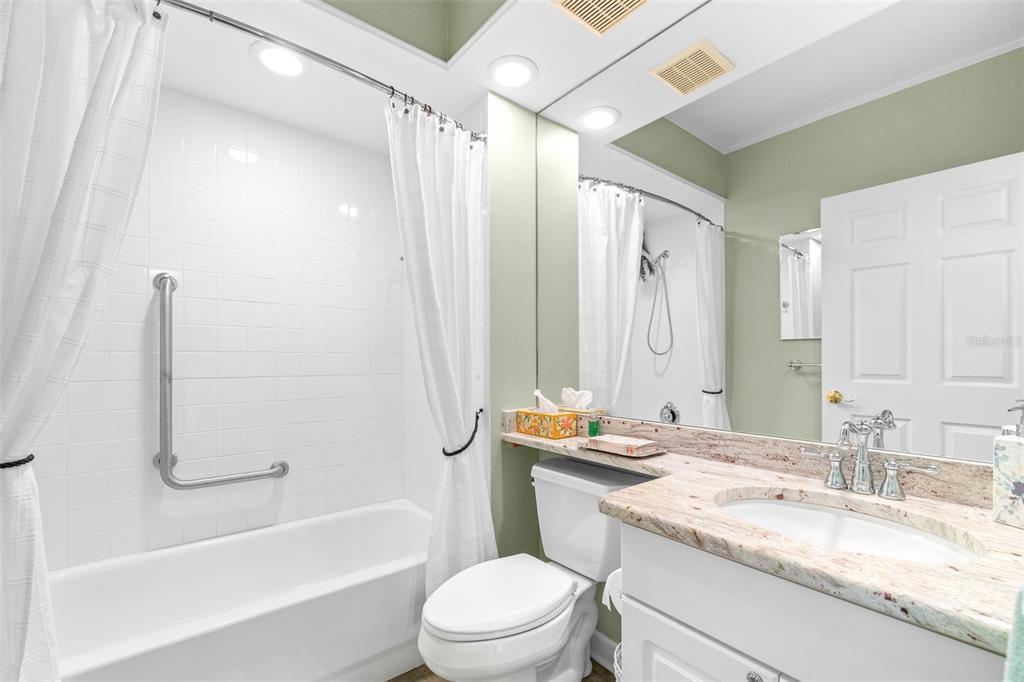 6399 Shoreline Drive, Unit 4206 St. Petersburg, FL 33708 - Photo 23 of 40 a bathroom with a granite countertop sink toilet and shower