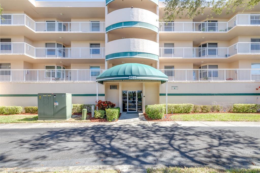 6399 Shoreline Drive, Unit 4206 St. Petersburg, FL 33708 - Photo 34 of 40 a front view of multi story residential apartment building with a yard