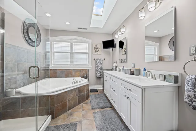 a bathroom with a tub a sink and a mirror