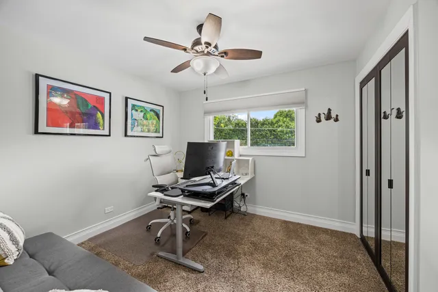 a view of a workspace with furniture and a window