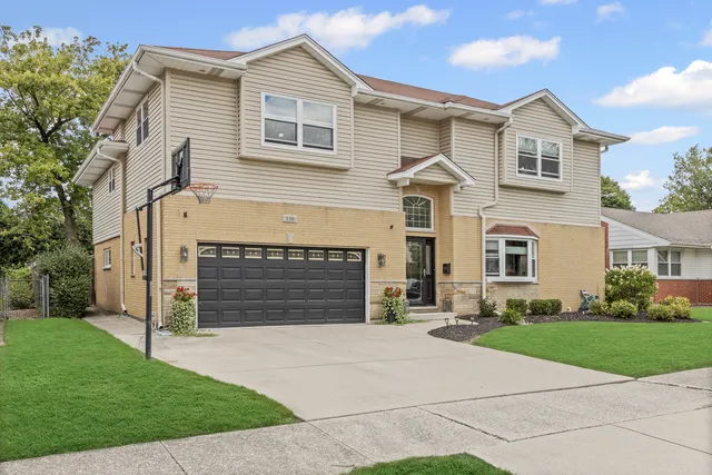 a front view of a house with a yard and garage