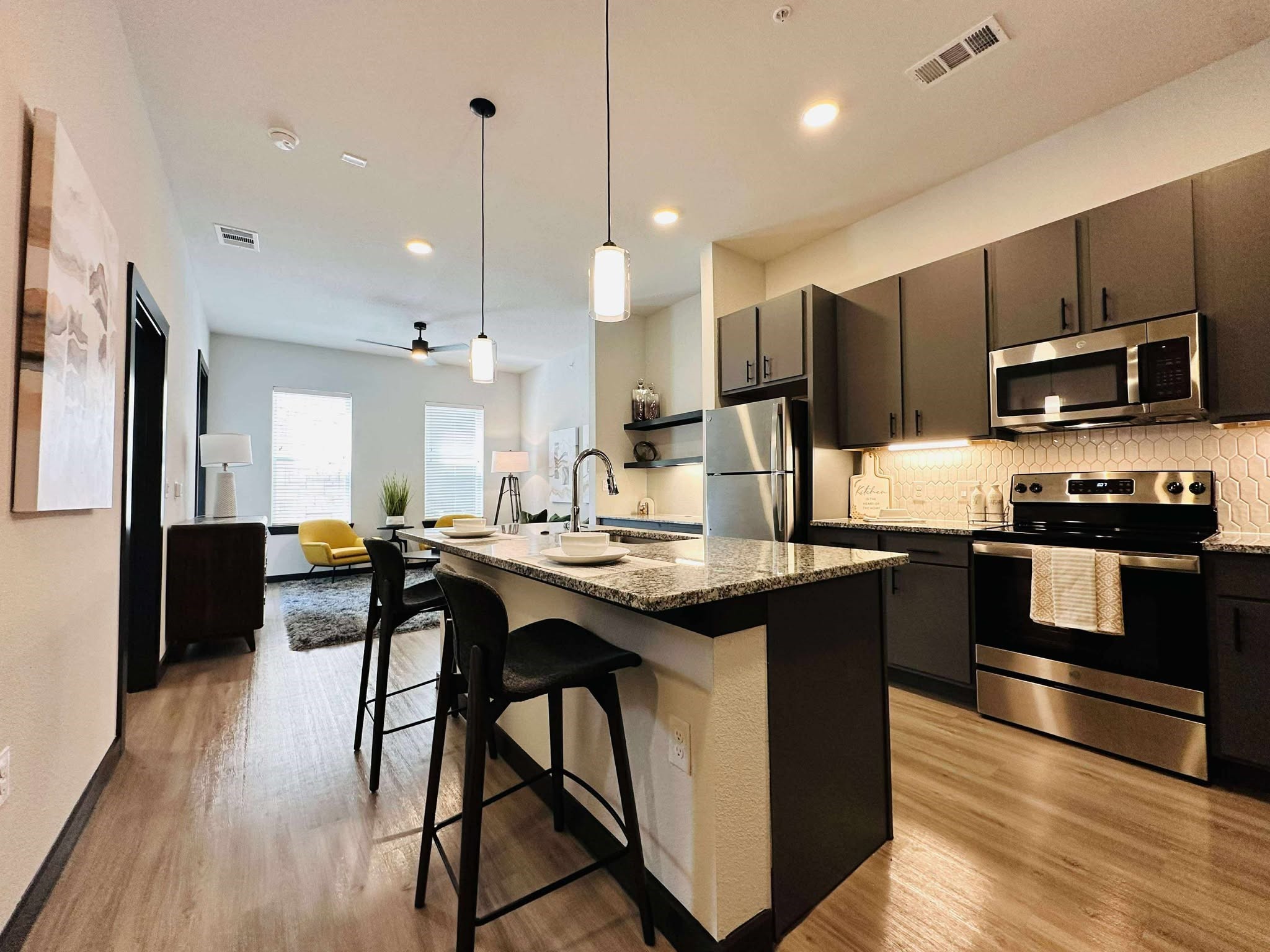 2603 North Fry Road, Unit A3 Katy, TX 77449 - Photo 9 of 16 a kitchen with stainless steel appliances granite countertop a stove a sink dishwasher a refrigerator and a dining table with wooden floor