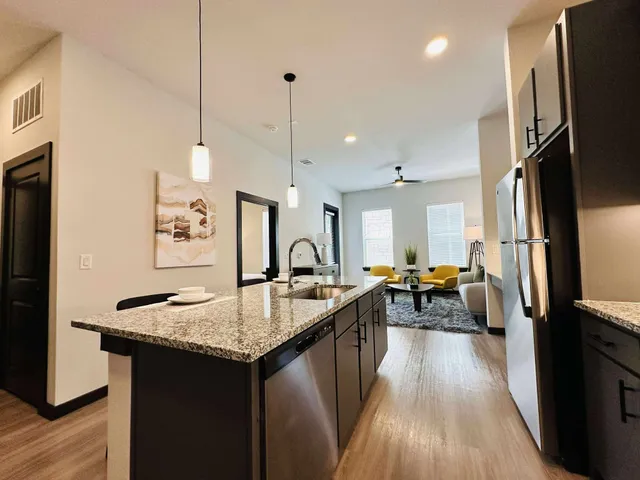 a kitchen with stainless steel appliances kitchen island granite countertop a sink counter space and cabinets