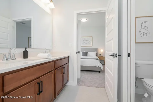 a en suite bathroom with a double vanity sink a mirror and a bathtub