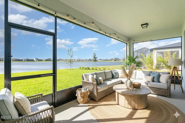 a living room with patio furniture and a large window