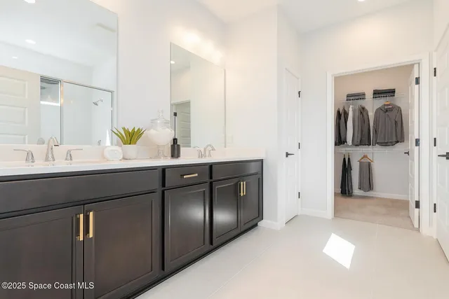 a en suite bathroom with a granite countertop sink and a mirror