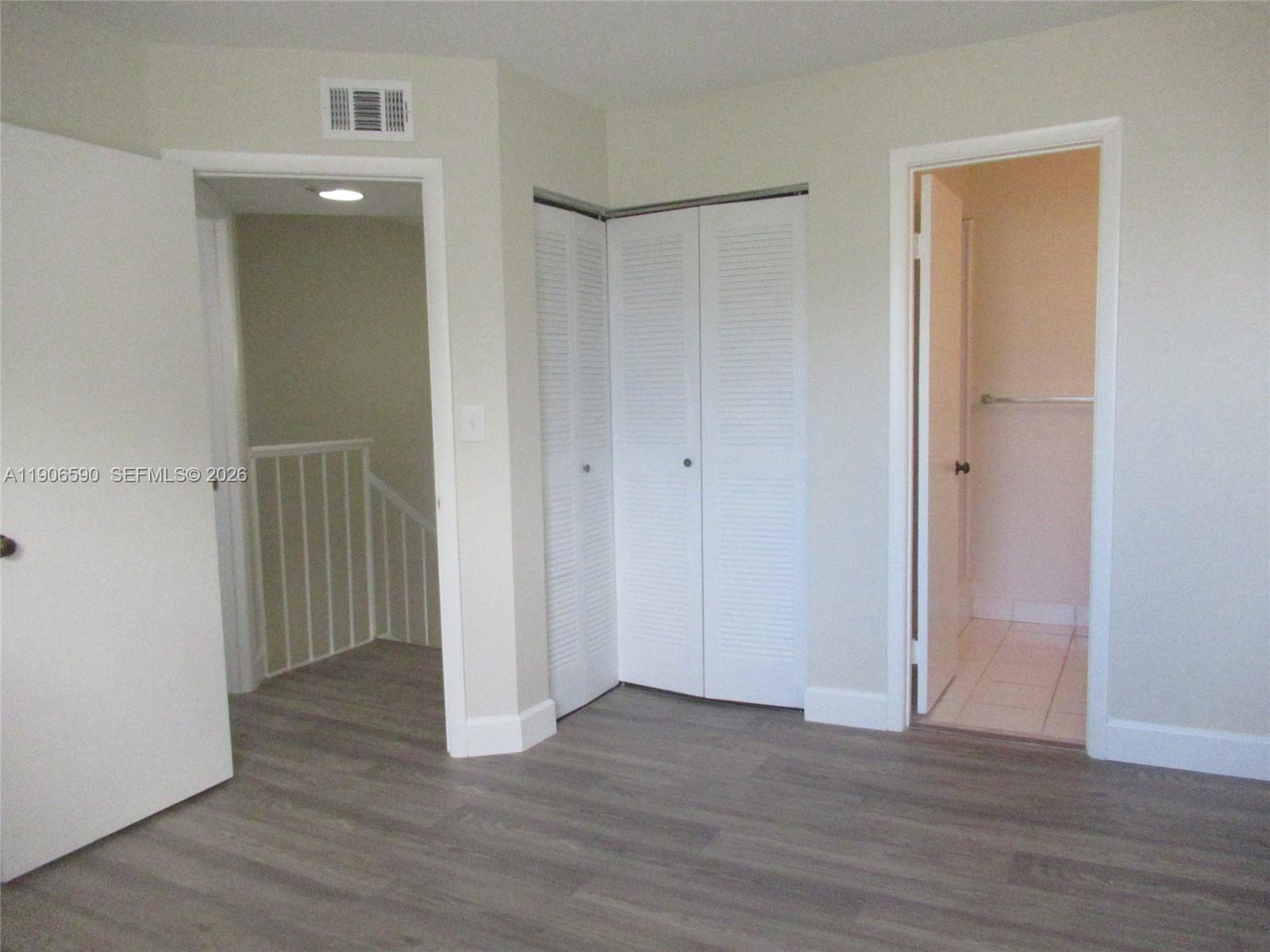 6825 Southwest 45th Lane, Unit 12 Miami, FL 33155 - Photo 12 of 17 an empty room with wooden floor & closet area