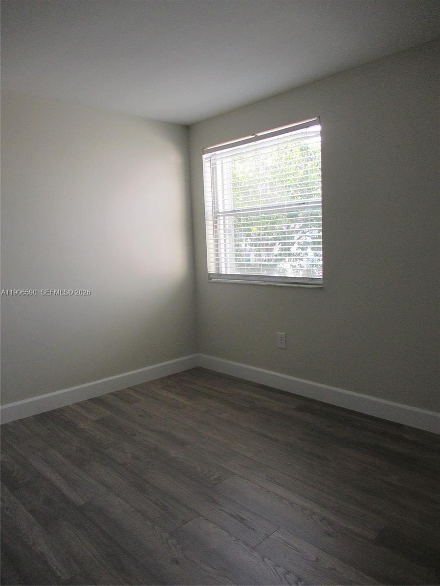 6825 Southwest 45th Lane, Unit 12 Miami, FL 33155 - Photo 13 of 17 an empty room with wooden floor and windows