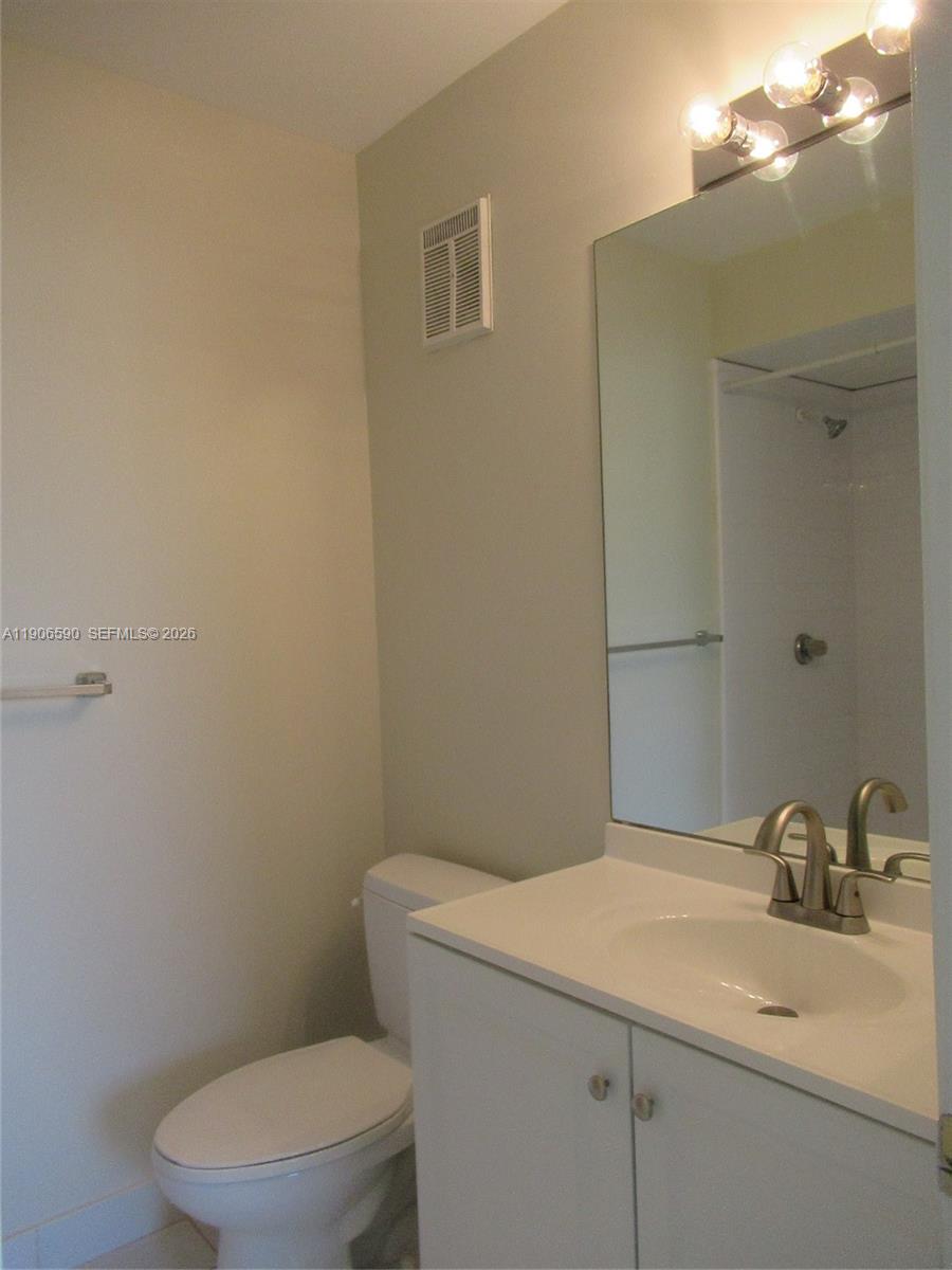 6825 Southwest 45th Lane, Unit 12 Miami, FL 33155 - Photo 14 of 17 a bathroom with a sink a toilet and a mirror