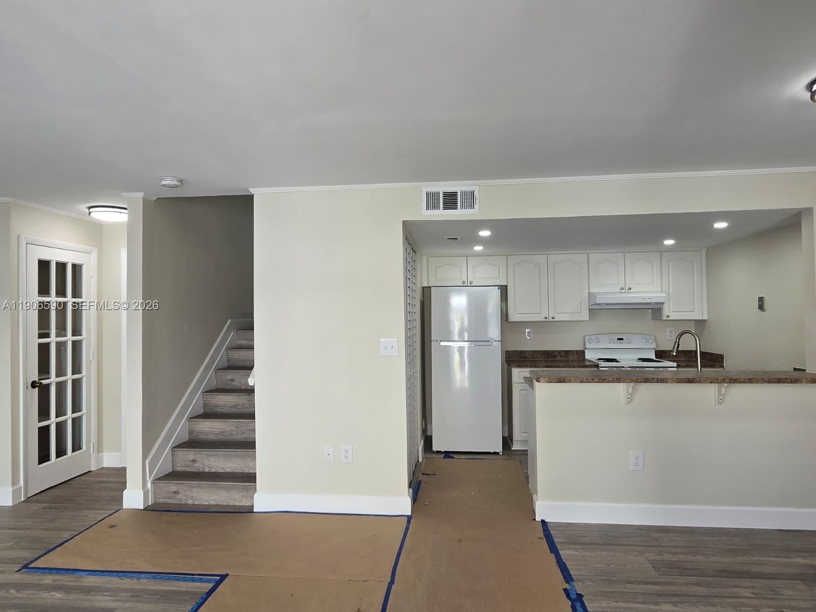 6825 Southwest 45th Lane, Unit 12 Miami, FL 33155 - Photo 4 of 17 a kitchen with stainless steel appliances a refrigerator and a stove top oven