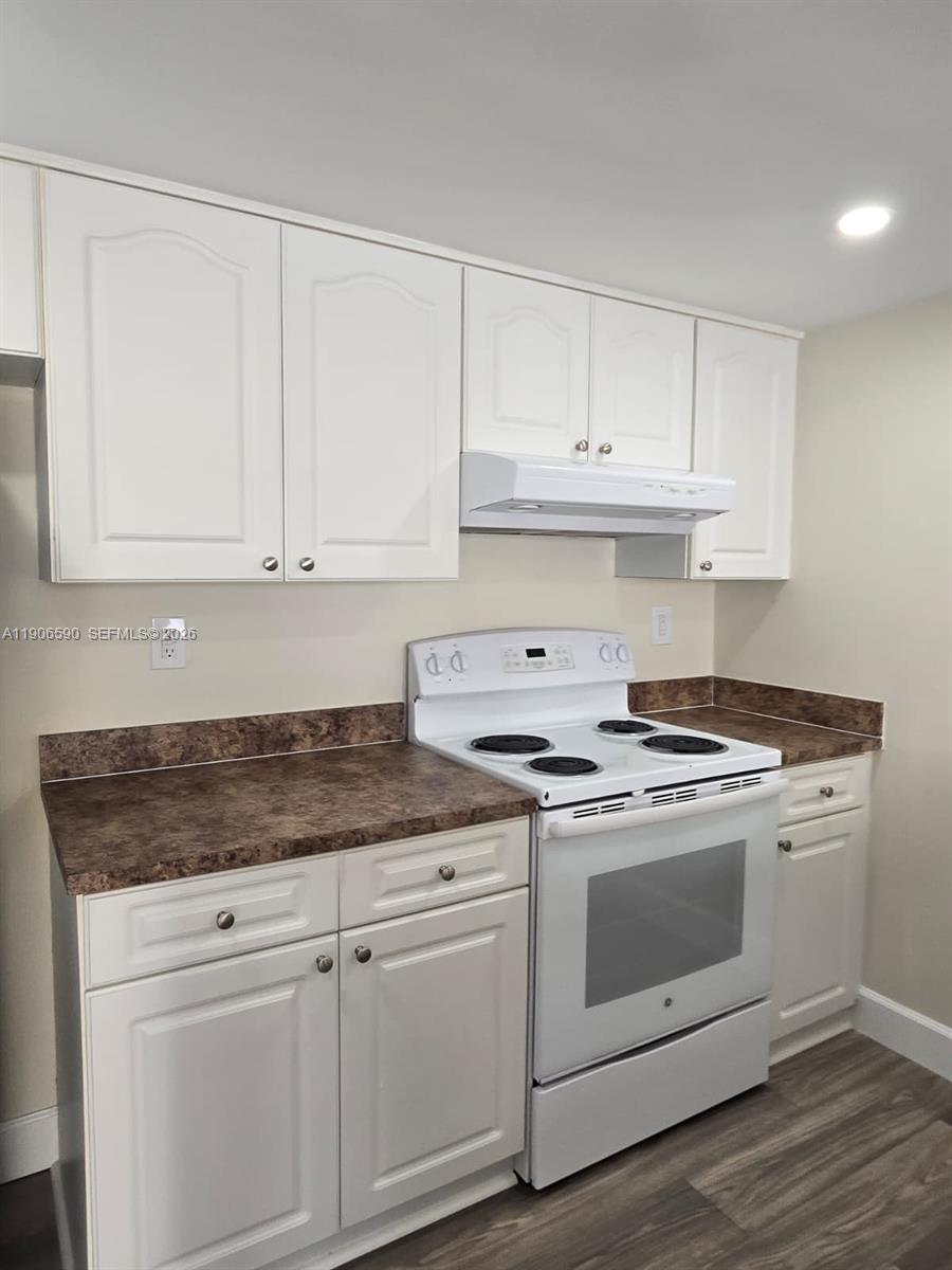 6825 Southwest 45th Lane, Unit 12 Miami, FL 33155 - Photo 6 of 17 a kitchen with granite countertop white cabinets and white stainless steel appliances