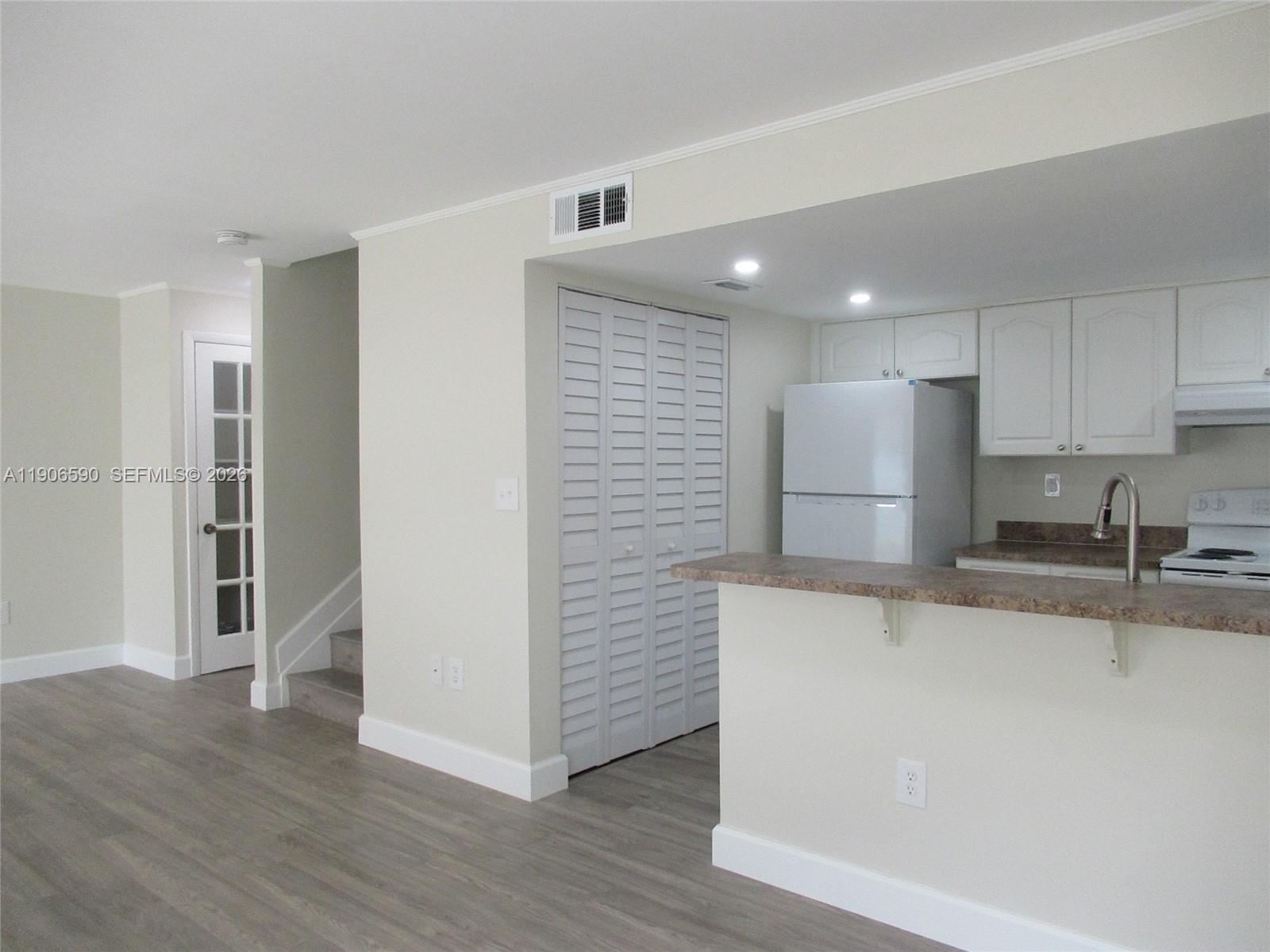 6825 Southwest 45th Lane, Unit 12 Miami, FL 33155 - Photo 7 of 17 a kitchen with stainless steel appliances granite countertop a refrigerator and a sink