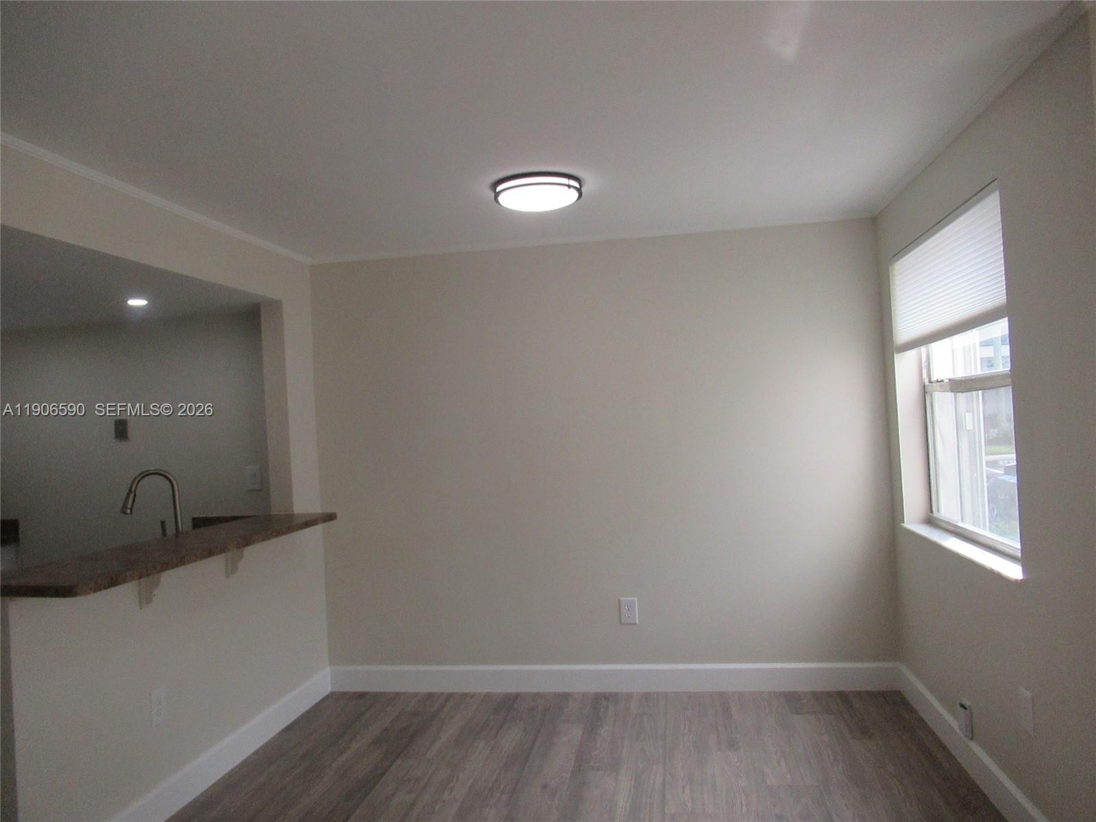 6825 Southwest 45th Lane, Unit 12 Miami, FL 33155 - Photo 8 of 17 a view of a room with wooden floor and windows