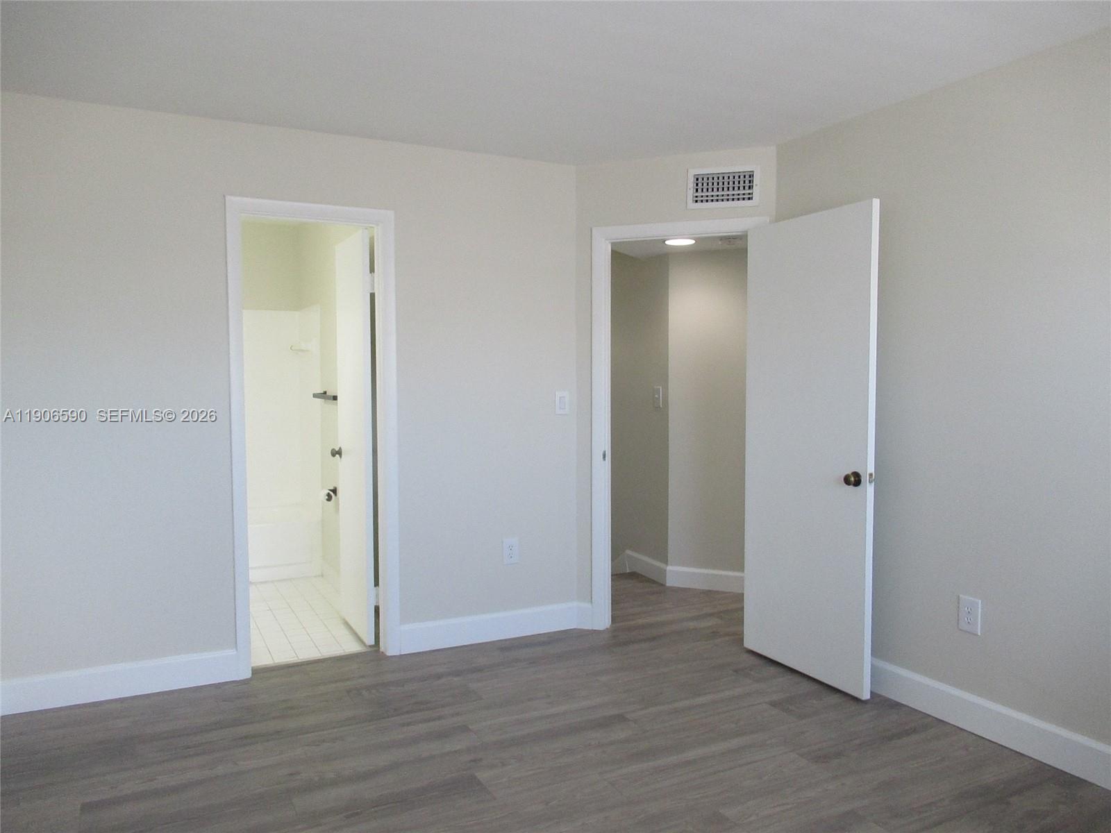 6825 Southwest 45th Lane, Unit 12 Miami, FL 33155 - Photo 9 of 17 a view of an empty room with wooden floor and closet