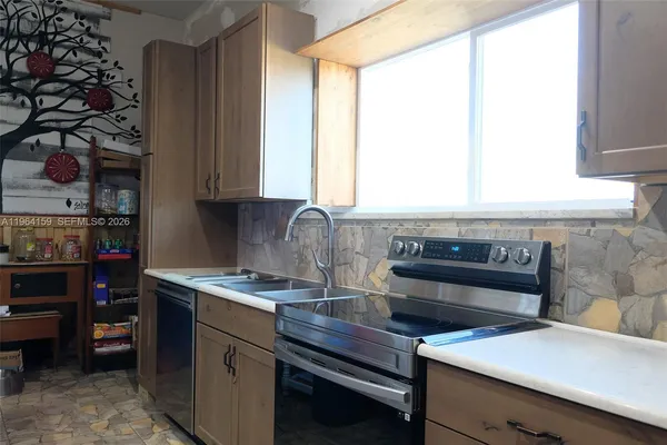 a kitchen with a stove a sink and a cabinets