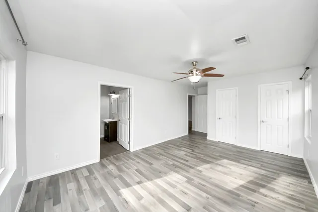 a view of empty room with wooden floor