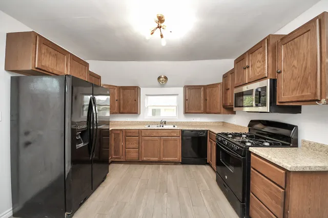 a kitchen with stainless steel appliances granite countertop a stove refrigerator and cabinets