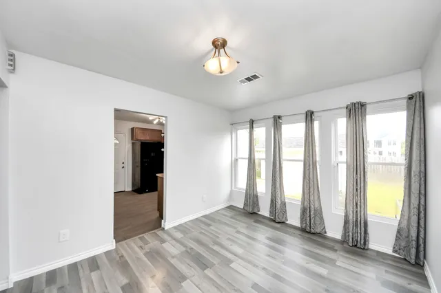 a view of an empty room with a window and a chandelier