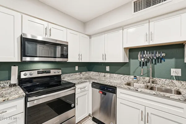 a kitchen with stainless steel appliances a stove a refrigerator and a microwave