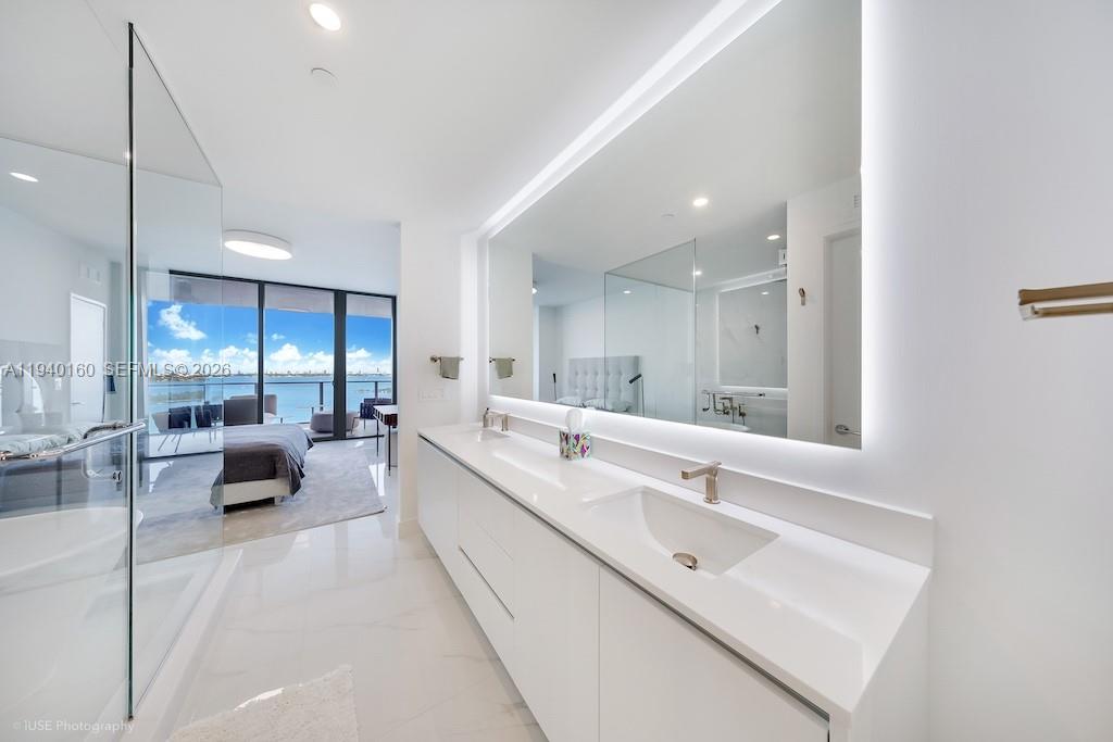 700 Northeast 24th Street, Unit 1403 Miami, FL 33137 - Photo 11 of 16 a bathroom with a double vanity sink and tub