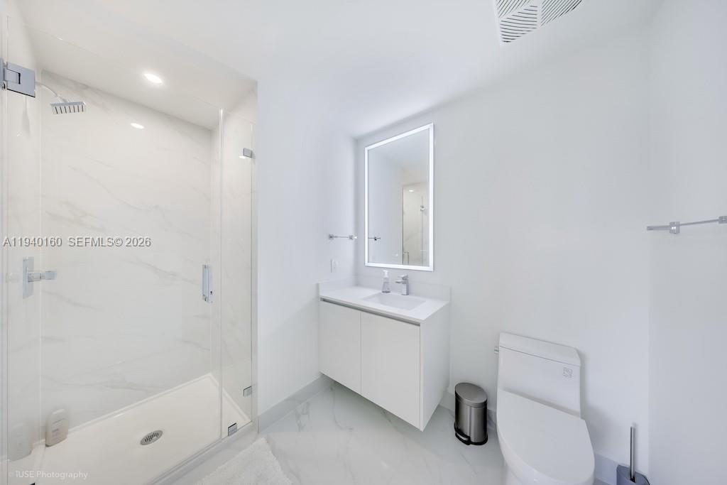 700 Northeast 24th Street, Unit 1403 Miami, FL 33137 - Photo 15 of 16 a bathroom with a sink a toilet and shower