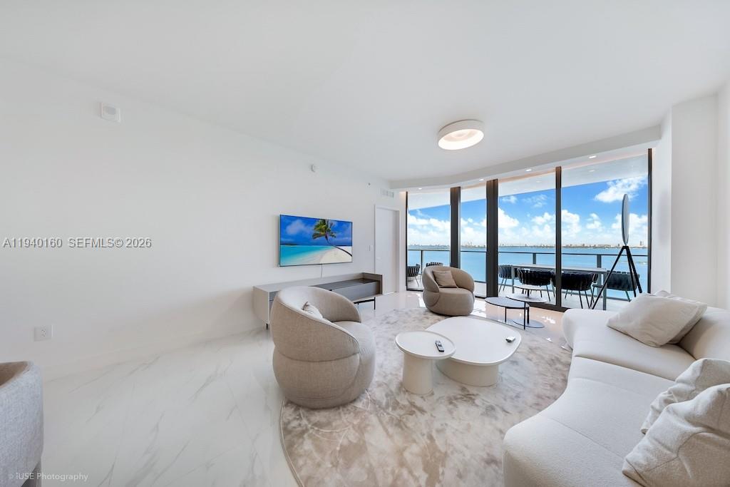 700 Northeast 24th Street, Unit 1403 Miami, FL 33137 - Photo 5 of 16 a living room with furniture and a large window