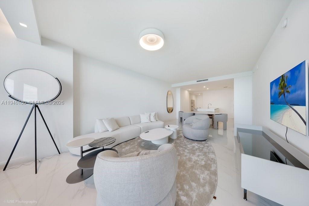 700 Northeast 24th Street, Unit 1403 Miami, FL 33137 - Photo 7 of 16 a living room with furniture and a lamp