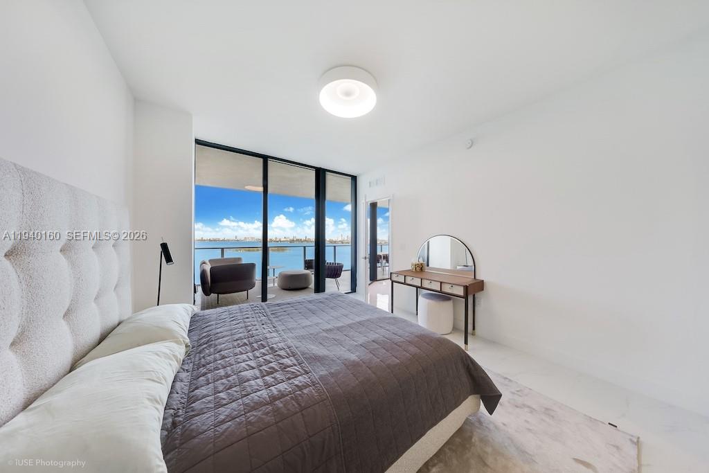 700 Northeast 24th Street, Unit 1403 Miami, FL 33137 - Photo 8 of 16 a spacious bedroom with a bed and a large window