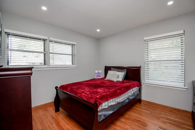 a bedroom with a bed and wooden floor