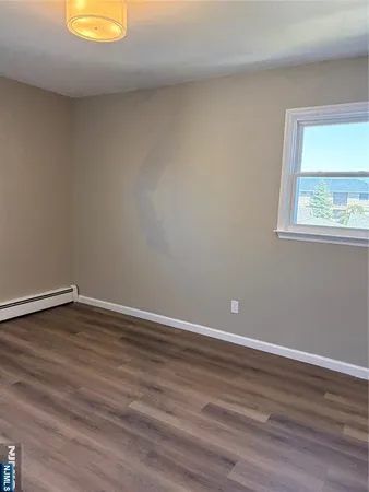a room with a wooden floor and a window