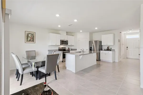 a view of kitchen with refrigerator microwave and dining table