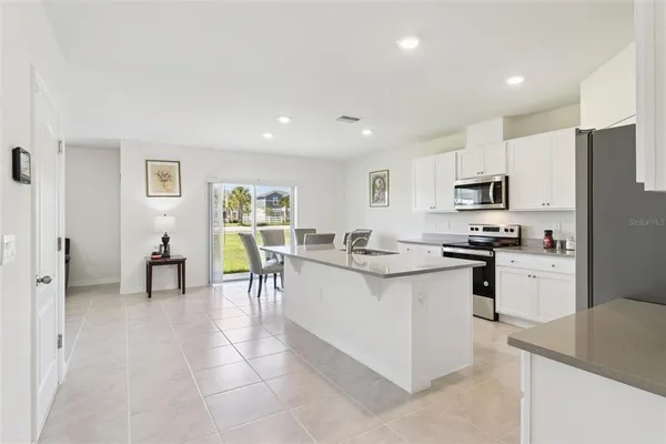 a kitchen with stainless steel appliances kitchen island granite countertop a refrigerator and microwave