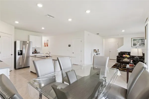 a view of kitchen with refrigerator stove dining table and chairs