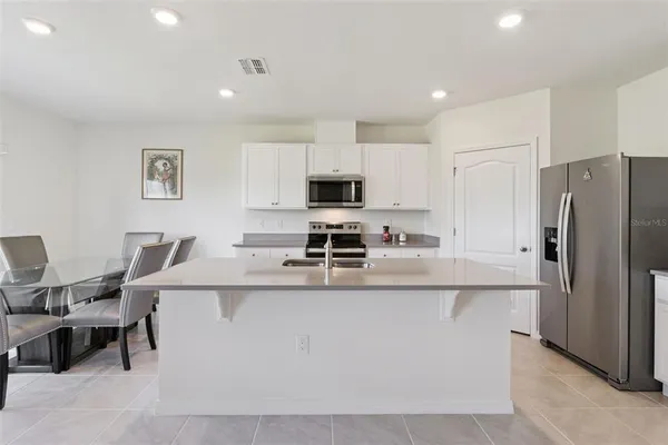 a kitchen with stainless steel appliances a stove refrigerator sink and microwave