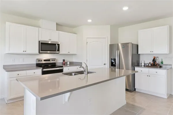 a kitchen with stainless steel appliances a refrigerator sink stove and microwave