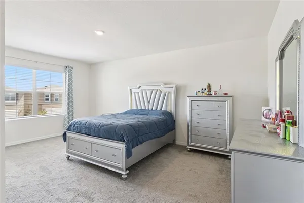 a spacious bedroom with a bed and dresser