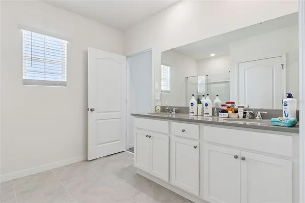 a bathroom with cabinets and mirror