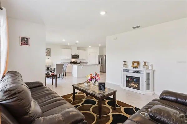 a living room with furniture kitchen view and a couch