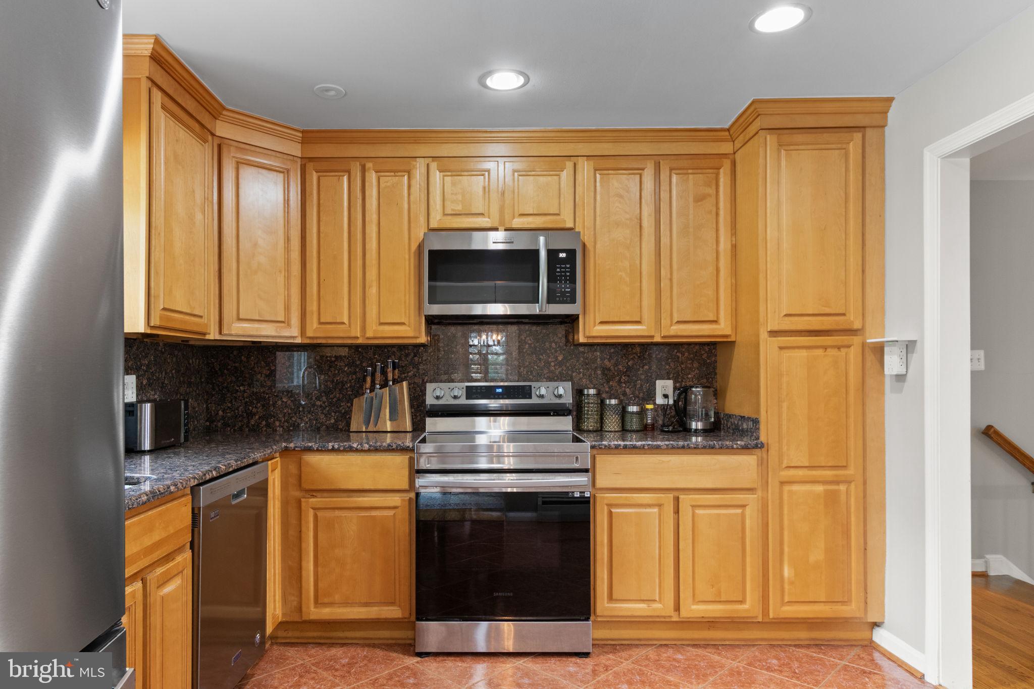 6700 Bulkley Road Lorton, VA 22079 - Photo 12 of 62 a kitchen with stainless steel appliances granite countertop a stove a sink and a microwave