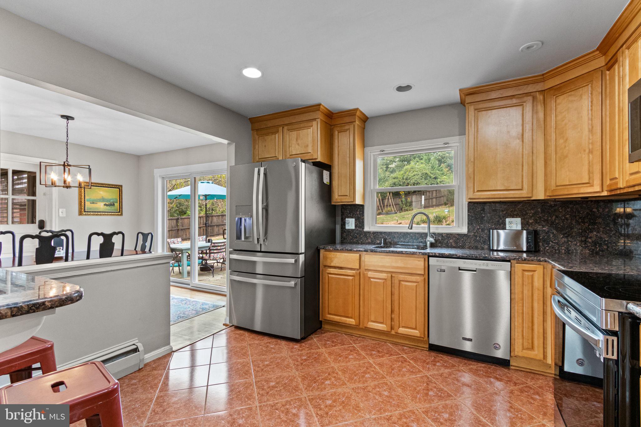 6700 Bulkley Road Lorton, VA 22079 - Photo 13 of 62 a kitchen with stainless steel appliances granite countertop a refrigerator a stove top oven a sink dishwasher and white cabinets with wooden floor