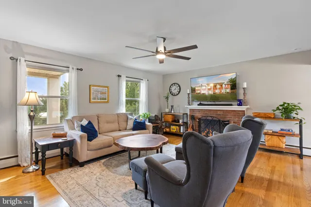 a living room with furniture a fireplace and a large window