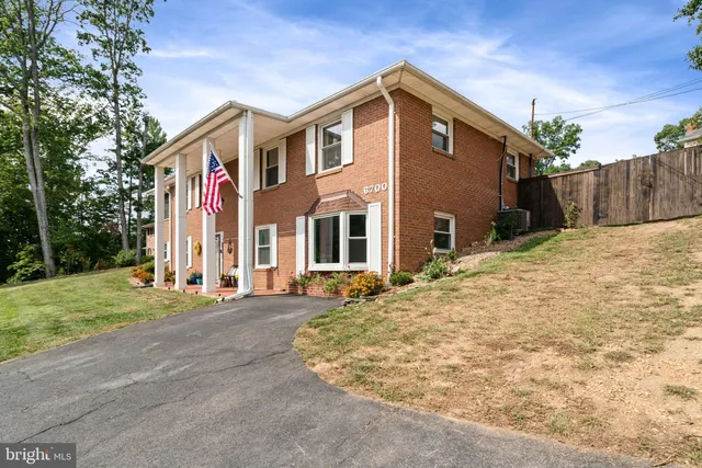 a view of a brick house with many windows and yard