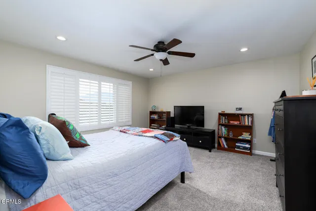 a bedroom with a bed a television and a desk