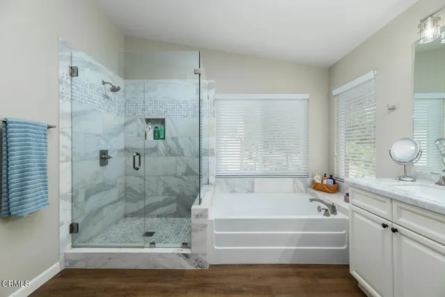 a bathroom with a granite countertop bathtub shower vanity and a sink