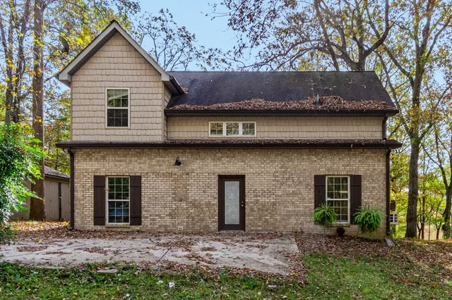 a brick house with a tree in front of the house