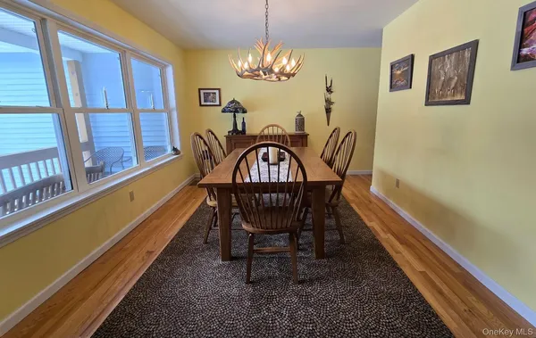 a view of a dining room with furniture a chandelier and wooden floor