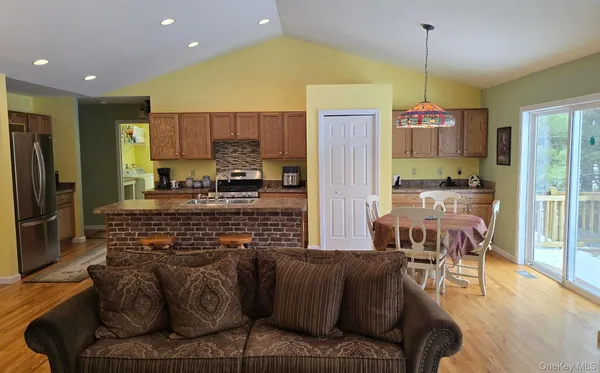 a kitchen with stainless steel appliances kitchen island granite countertop a refrigerator and a stove