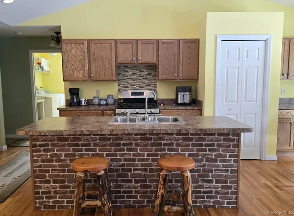 a kitchen with kitchen island granite countertop a stove sink and cabinets