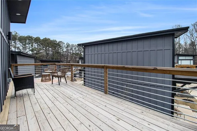 a roof deck with a table and chairs and wooden floor