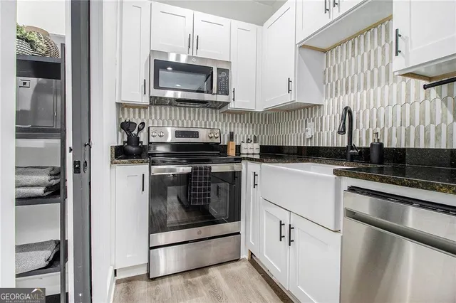a kitchen with white cabinets and stainless steel appliances